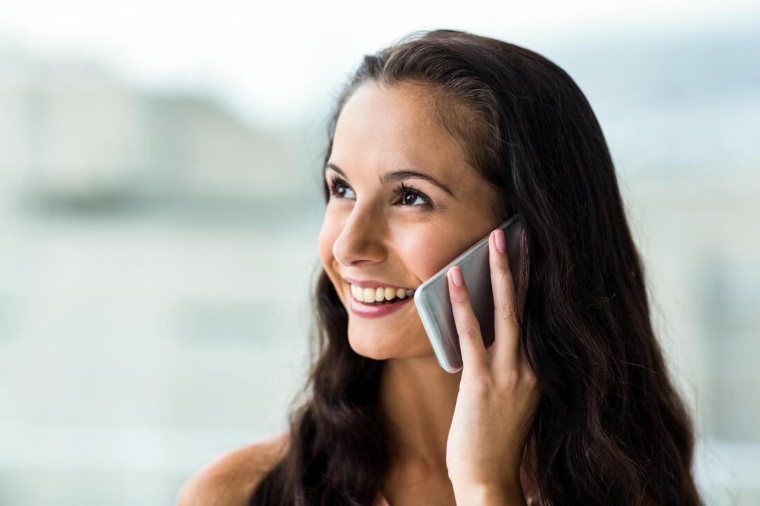 girl smiling while talking to her phone