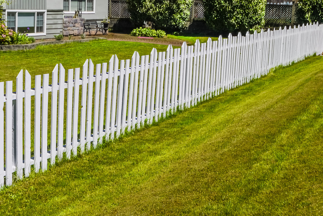 small white fence on a grassy land 